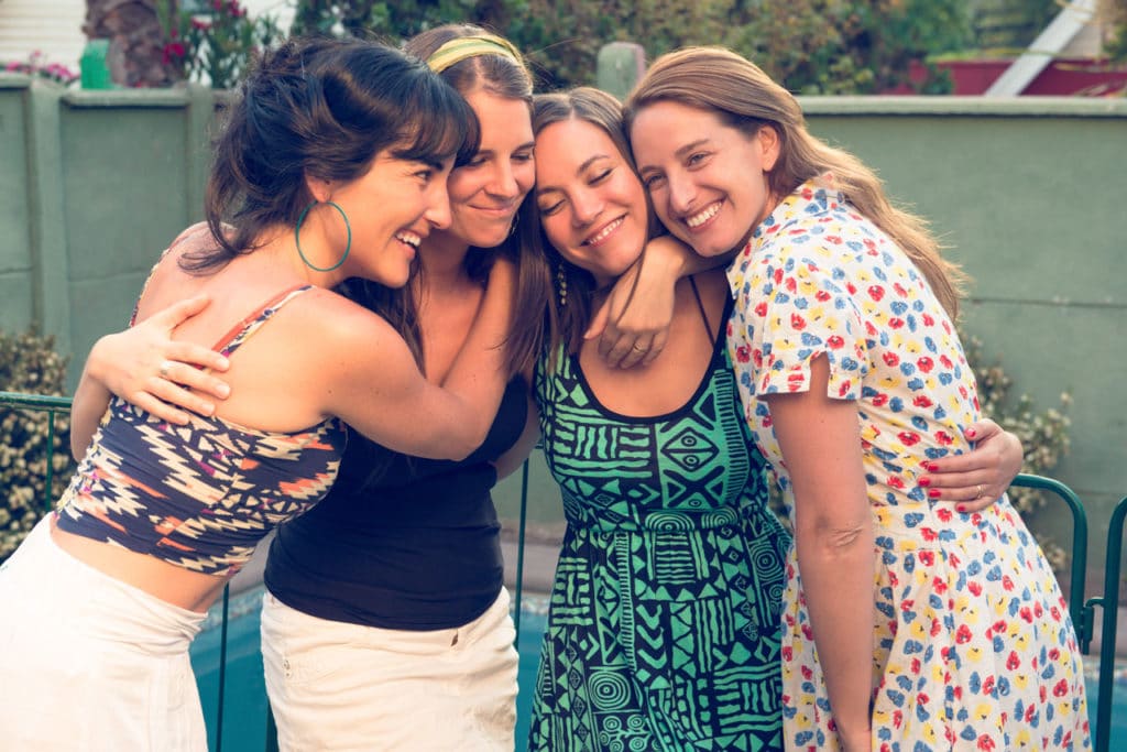 Vier glückliche Frauen, die sich umarmen